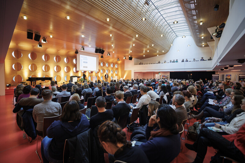 Blick in den Veranstaltungssaal mit gefüllten Sitzreihen – lebendige Atmosphäre bei einer professionellen Eventproduktion von Proesler Kommunikation.